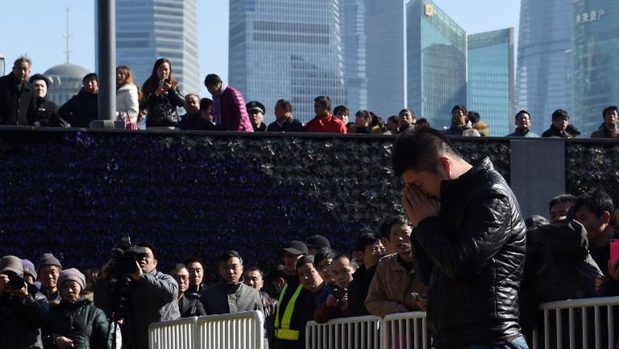 Un homme en prière le 1er janvier 2015 sur le Bund, après la bousculade meurtrière pendant la nuit de la Saint-Sylvestre à Shangaï