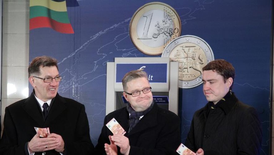 Le Premier ministre lituanien Algirdas Butkevicius, le président de la Banque de Lituanie Vitas Vasiliauskas, et le Premier ministre estonien Taavi Roivas avec des billets d'euro symboliquement retirés le 1er janvier 2015 d'un distributeur à Vilnius
