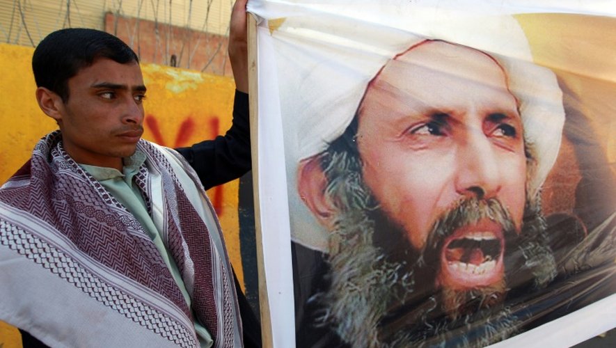 Photo du dignitaire chiite Nimr al-Nimr brandie par un manifestant le 18 octobre 2014 devant l'ambassade d'Arabie saoudite à Sanaa pour protester contre la condamnation à mort du leader d'opposition