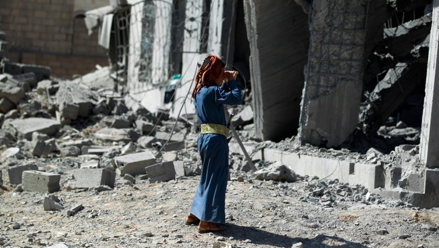 Un homme se tient devant un immeuble détruit par un bombardement de la coalition menée par l'Arabie saoudite, à Sanaa le 28 octobre 2015