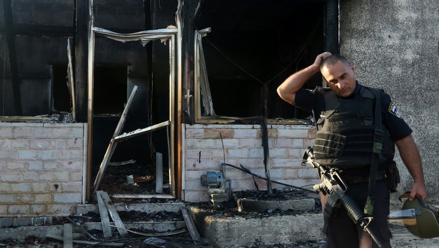 Un membre des forces de sécurité israéliennes inspecte une maison incendiée par des juifs extrémistes dans le village de Douma en Cisjordanie, le 31 juillet 2015