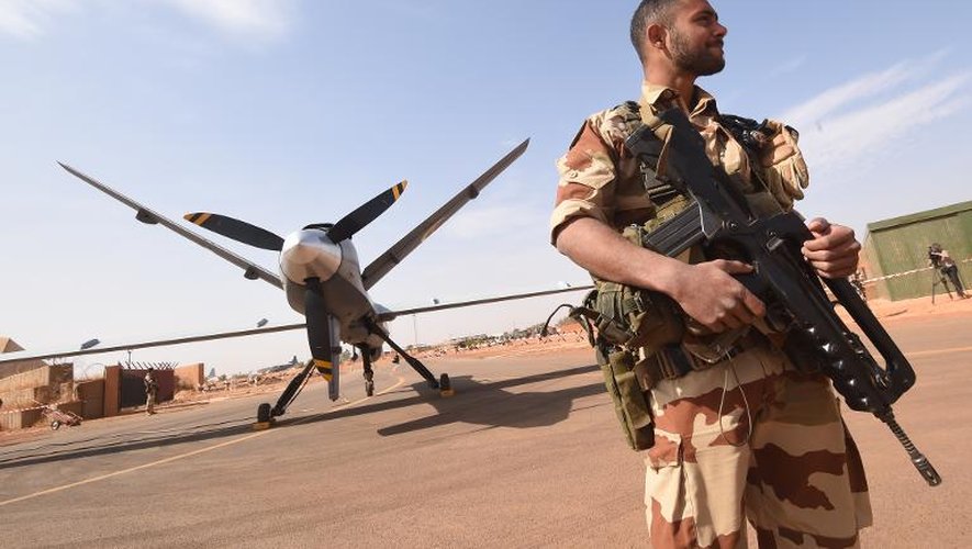 Un soldat français monte la garde le 2 janvier 2015 près d'un drone américain Reaper à la base militaire de Niamey, au Niger