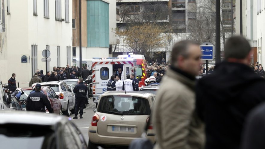 Pompiers et policiers devant le siège de l'hebdomadaire satirique Charlie Hebdo le 7j janvier 2015 à Paris
