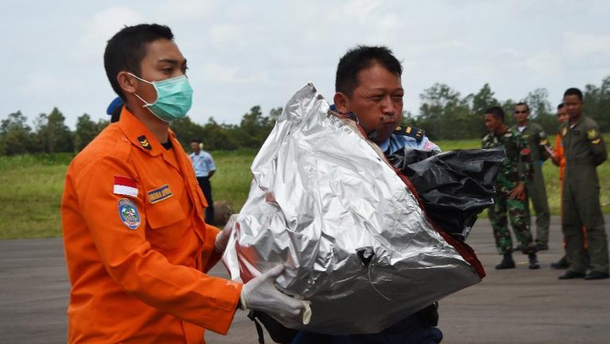 Des membres des secours indonésiens transportent des débris del'avion d'AirAsia repêchés en mer de Java, le 2 janvier 2015 à Pangkalan Bun