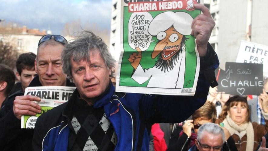 Des manifestants lors de la marche républicaine du 11 janvier 2015 à Paris brandissent des exemplaires du dernier Charlie Hebdo