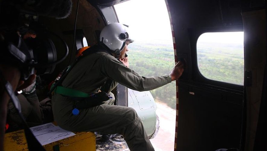 Un membre de l'équipe de secours indonésienne survole le 3 janvier 2015 la zone du crash en mer de Java