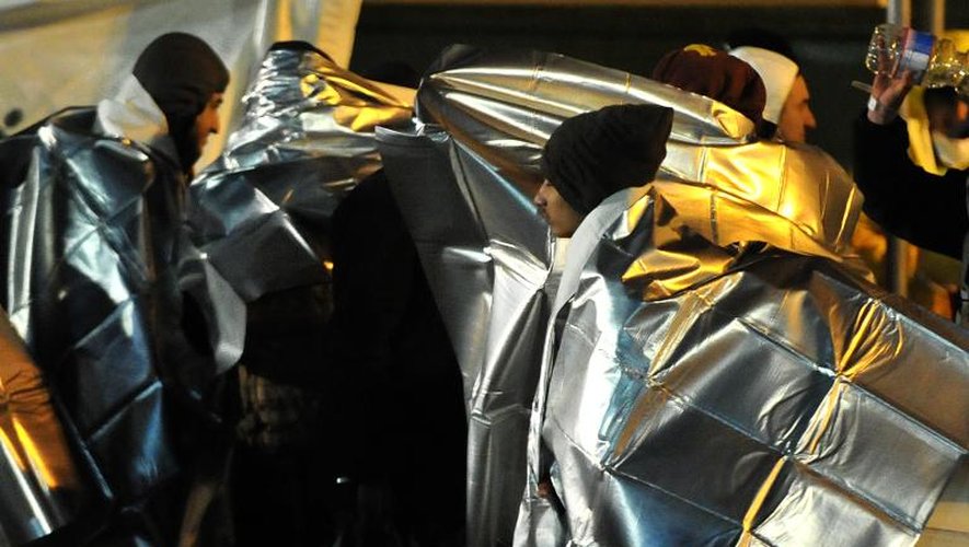 Des migrants débarqués d'un cargo abandonné par son équipage, reçoivent les premières aides d'urgence le 3 janvier 2015 à Corigliano