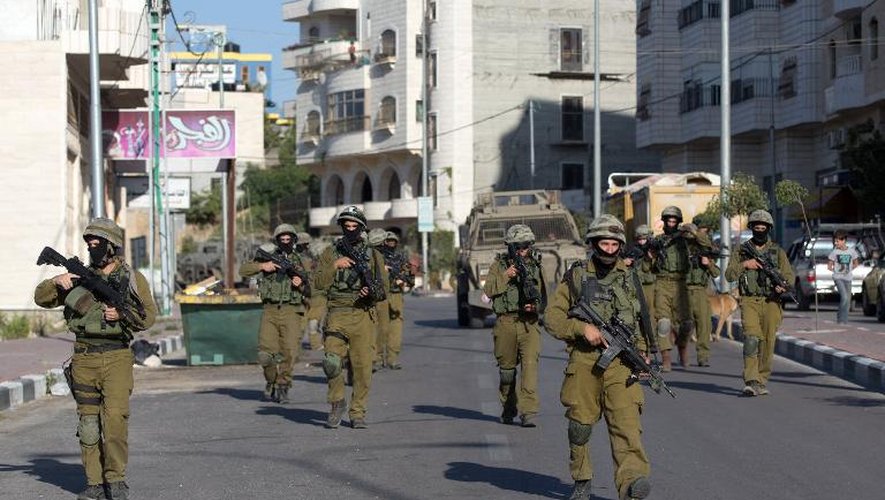 Des soldats israéliens patrouillent dans les rues d'Hebron le 17 juin 2014