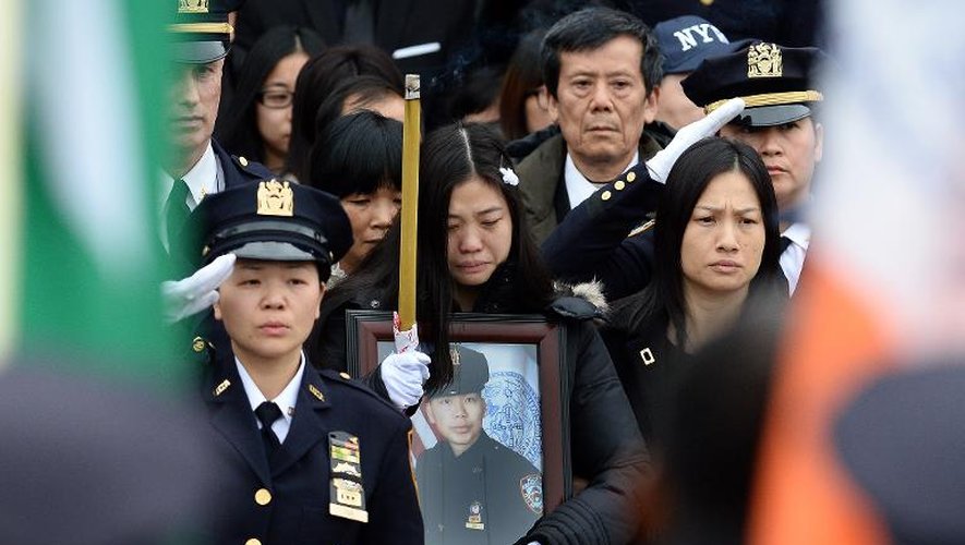 Pei Xia Chen (c), veuve du policier assassiné Wenjian Liu, brandit son portrait lors de ses funérailles à New York le 4 janvier 2015