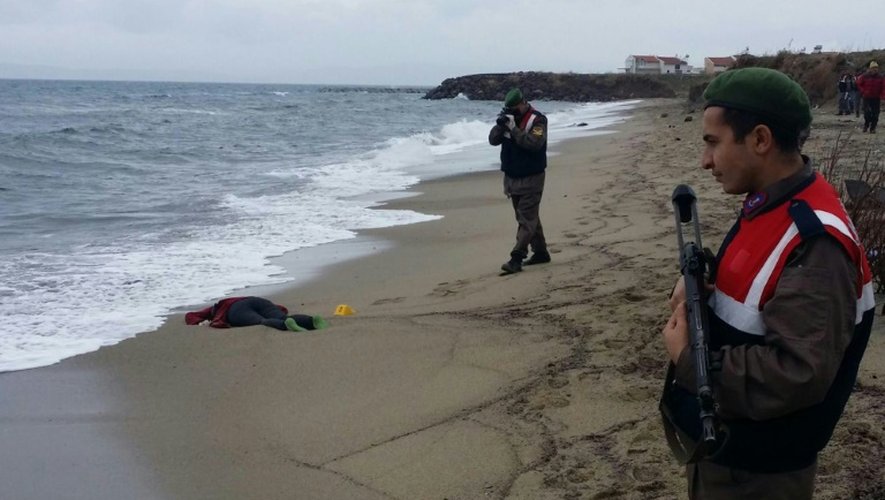 Des militaires turcs prennent des photos d'un migrant échoué sur une plage dans le district de Dikili le 5 janvier 2016