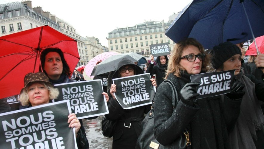 "Nous sommes tous Charlie" affichent des passants lors d'une minute de silence le 8 janvier 2015 place de la Bourse à Paris