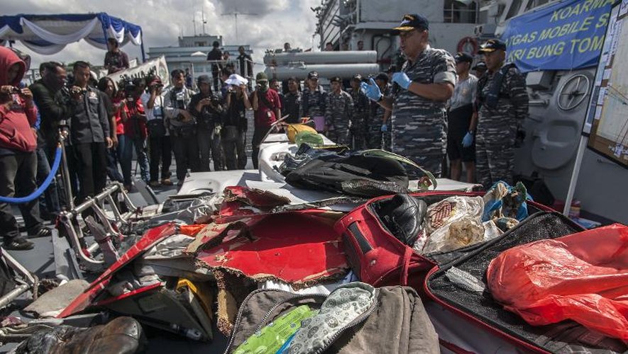 Des effets des passagers du vol d'AirAsia qui s'est écrasé en mer sont rassemblés le 5 janvier 2015 sur un navire