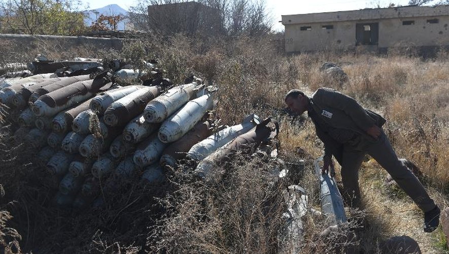 Un homme examine le 7 décembre 2014 des bombes entreposées à Jangalak, au sud de Kaboul