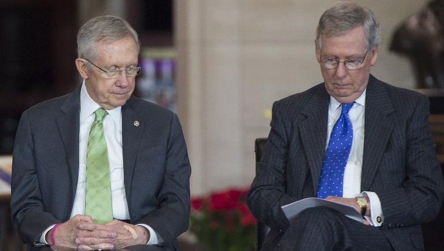 Le leader de la majorité républicaine au Sénat Mitch McConnell (D) et le leader démocrate Harry Reid lors d'une cérémonie au Capitole le 10 décembre 2014
