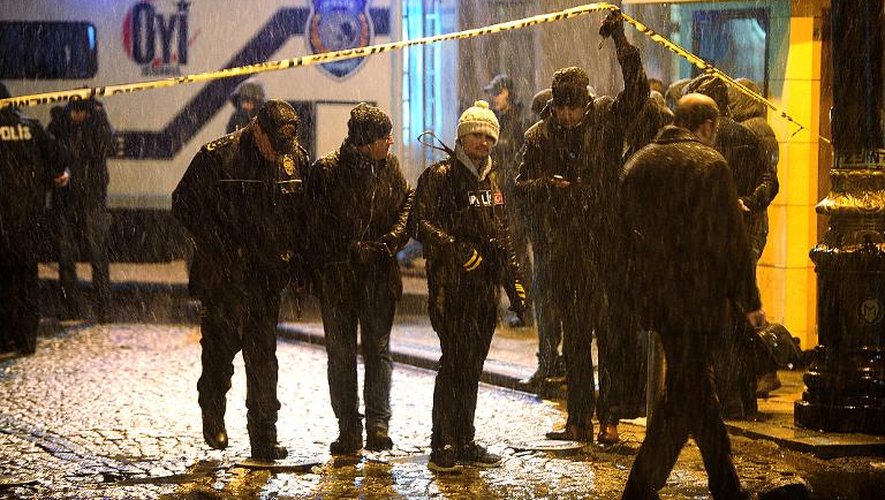 Des policiers turcs devant le poste de police où une femme kamikaze s'est fait exploser, dans le centre d'Istanbul le 6 janvier 2014