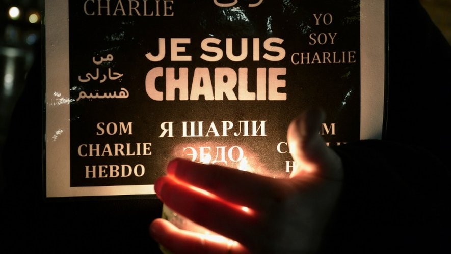 Un homme porte une bougie et une pancarte avec les mots "Je suis Charlie", le 8 janvier 2015 à Strasbourg