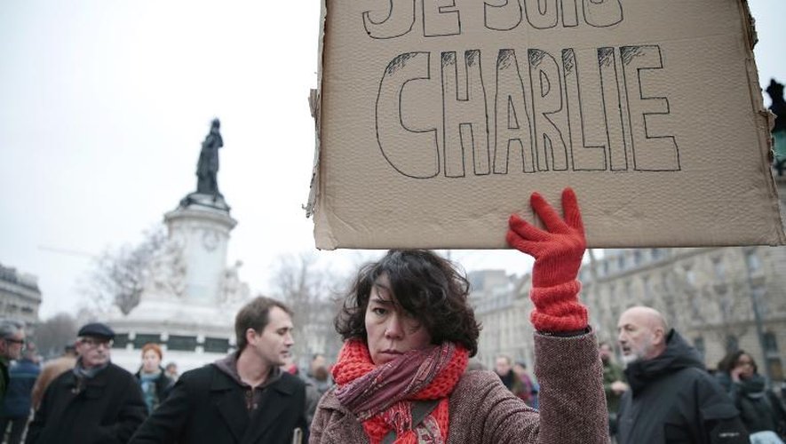 Une femme tient une pancarte "Je suis Charlie" lors d'un rassemblement organisé place de la République à Paris après l'attaque du journal Charlie Hebdo qui a fait 12 morts, le 7 janvier 2015