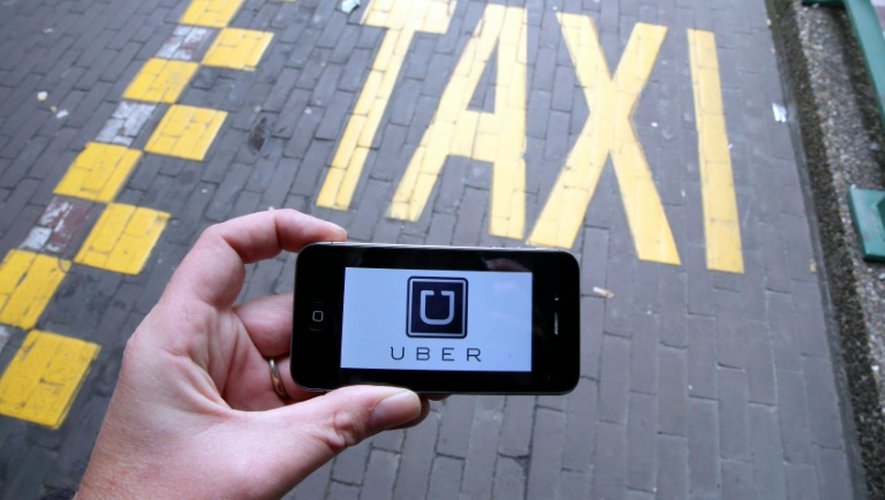 Le logo d'Uber affiché sur un smartphone pendant une manifestation de taxis à Bruxelles contre l'application, le 13 septembre 2015