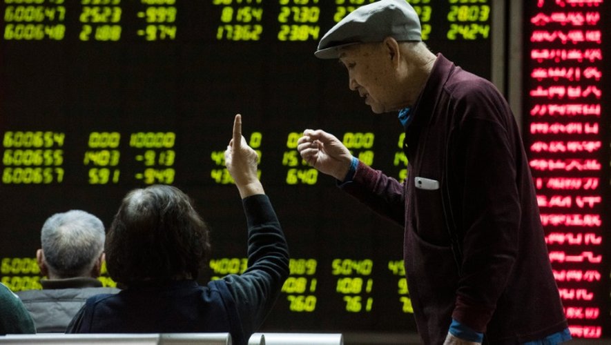 Des investisseurs devant des écrans de cotation dans une société de Bourse à Pékin le 7 janvier 2015