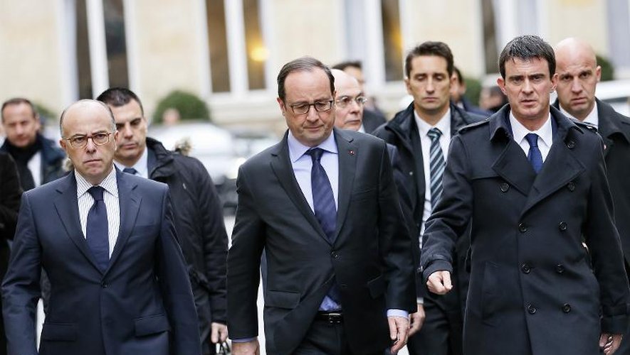 François Hollande est entouré par le ministre de l'Intérieur Bernard Cazeneuve (G) et le Premier ministre Manuel Valls, le 9 janvier 2015 à Paris