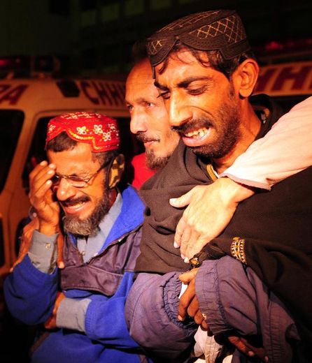 Des proches des victimes de la collision entre un bus et un camion citerne, rassemblés devant l'hôpital le 11 janvier 2015 à Karachi