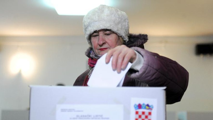 Une femme dépose son bulletin dans l'urne le 28 décembre 2014 à Zagreb