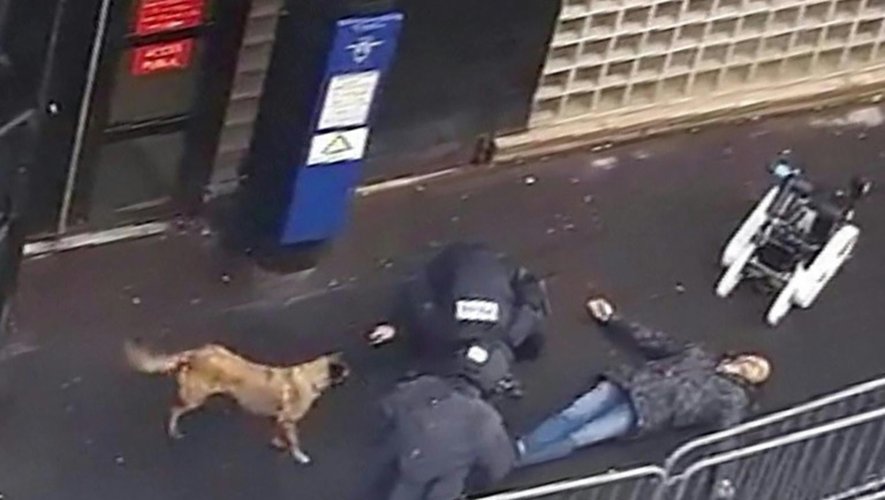 Une capture d'écran d'une vidéo obtenue par l'AFP montre la police et un robot démineur autour du cadavre d'un homme abattu par la police devant le commissariat de la Goutte-d'Or à Paris, le 7 janvier 2016