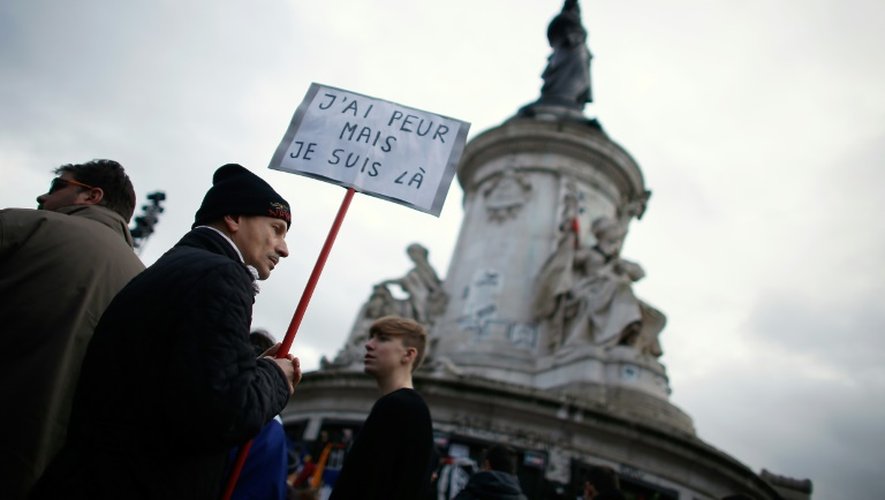 Un homme porte une pancarte à l'occasion du rassemblement en hommage aux victimes des attentats, le 10 janvier 2016 à Paris