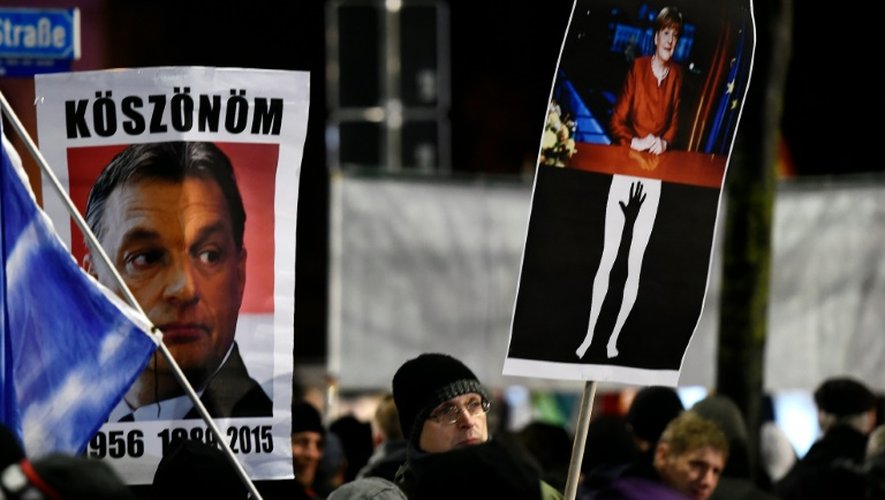 Photos du Premier ministre hongrois Viktor Orban et de la chancelière Angela Merkel, brandis par des manifestants rassemblés le 11 janvier 2016 à Leipzig à l'appel  du mouvement islamophobe Pegida