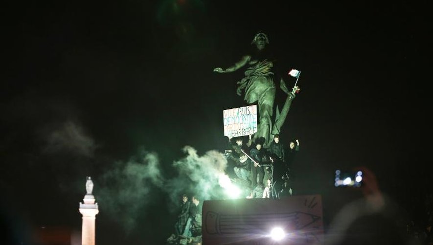 "Vite, plus de démocratie" inscrit sur la statue de la Liberté place de la République lors de la marche républicaine le 11 janvier 2015 à Paris