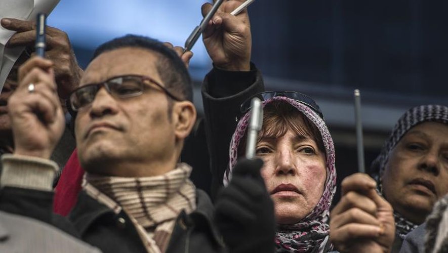 Des stylos brandis lors d'un rassemblement silencieux devant le syndicat des journalistes le 11 janvier 2015 au Caire