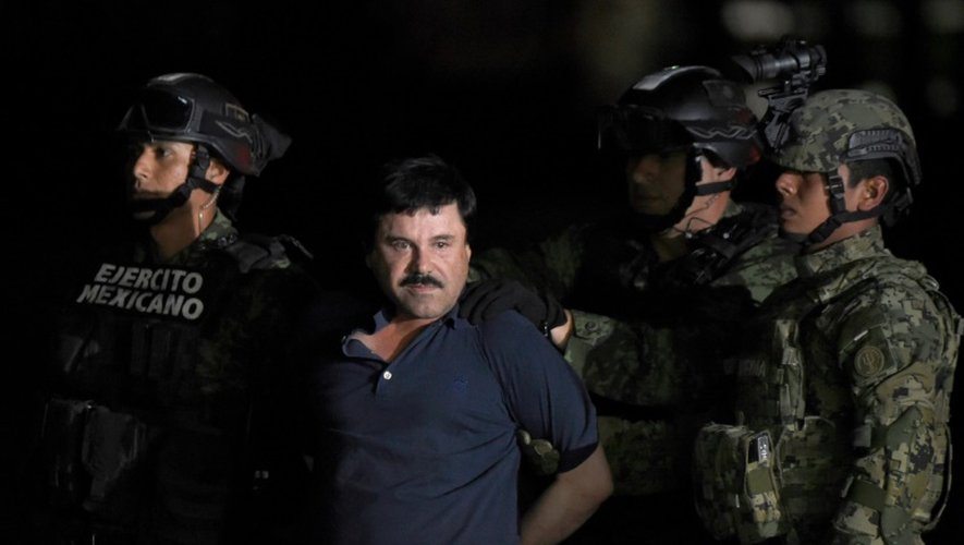 Le baron de la drogue El Chapo maintenu par des policiers peu après son arrestation, le 8 janvier 2016 sur le tarmac de l'aéroport de Mexico