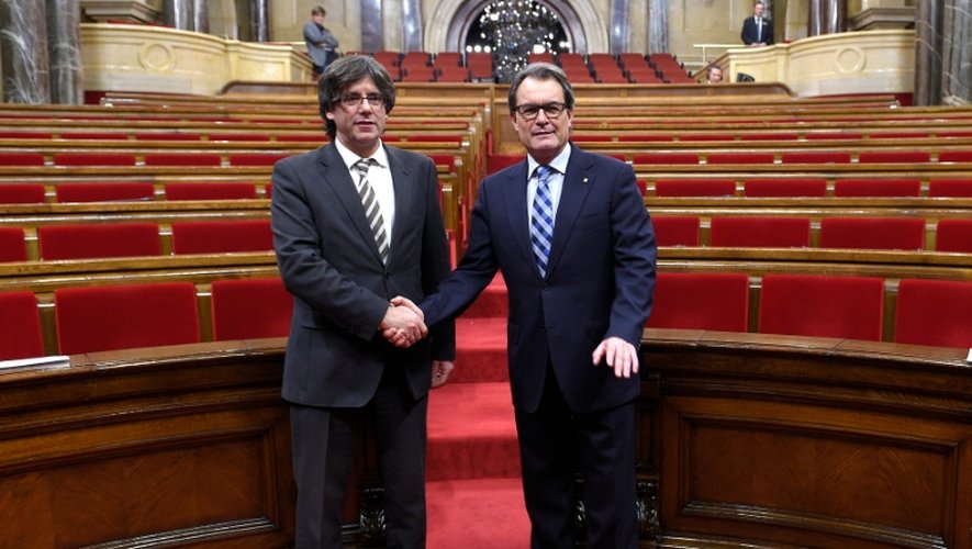 Le nouveau président de la Catalogne, Carles Puigdemont (g), félicité par son prédécesseur, Arthur Mas, lors de son investiture, le 10 janvier 2016 à Barcelone