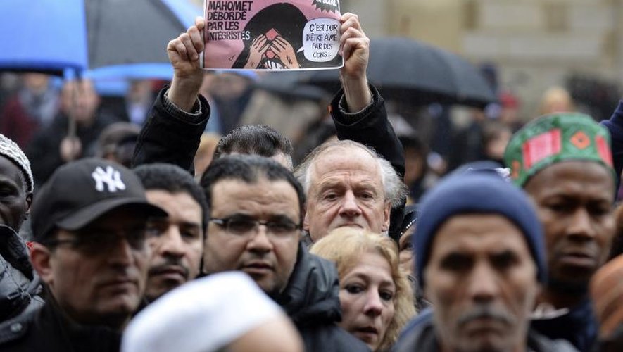 Un homme brandit une ancienne Une du journal Charlie Hebdo comportant une caricatures du prophète Mahomet, le 9 janvier 2015 à Bordeaux