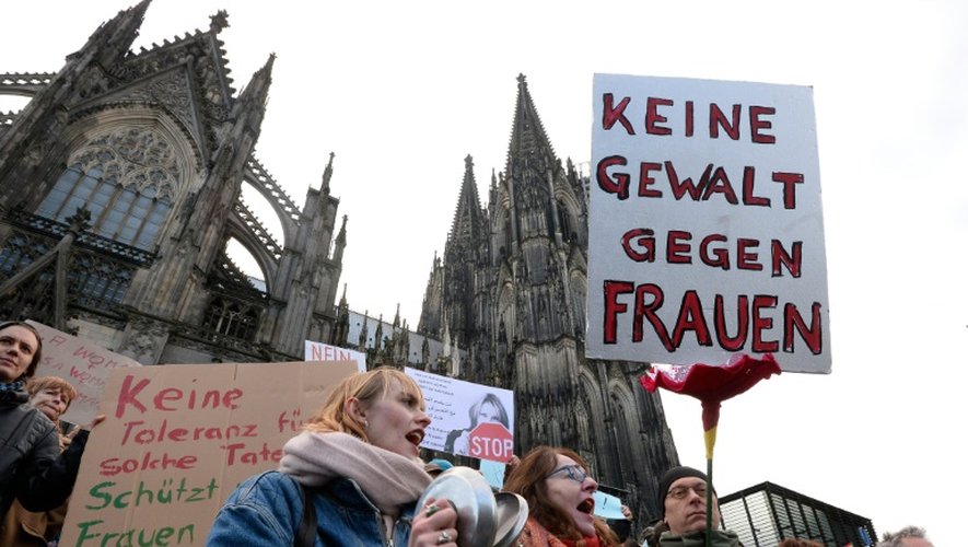 Un homme tient une pancarte "pas de violence contre les femmes" lors d'une manifestation devant la cathédrale de Cologne le 9 janvier 2015