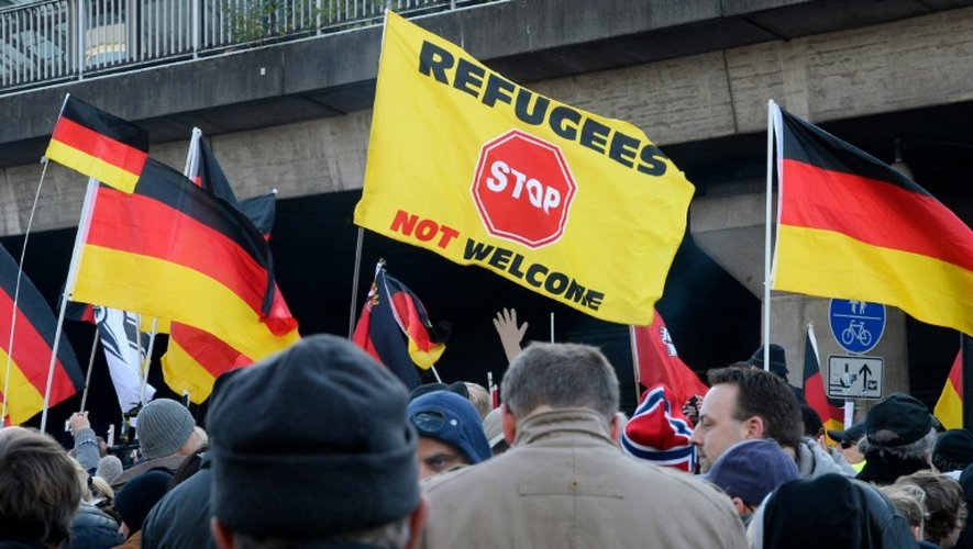 "Stop. Les réfugiés ne sont pas les bienvenus" sur un drapeau lors d'une manifestation de l'extrême droite devant la gare de Cologne le 10 janvier 2016