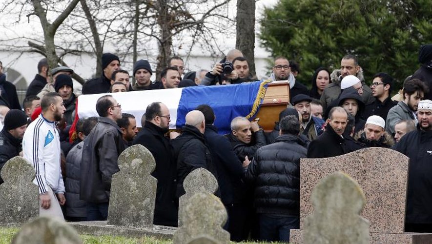 De nombreuses personnes portent le cercueil du policier Ahmed Merabet, assassiné le 7 janvier 2015 en marge de l'attentat contre le journal satirique Charlie Hebdo, au cimetière musulman de Bobigny (Seine-Saint-Denis) le 13 janvier 2015