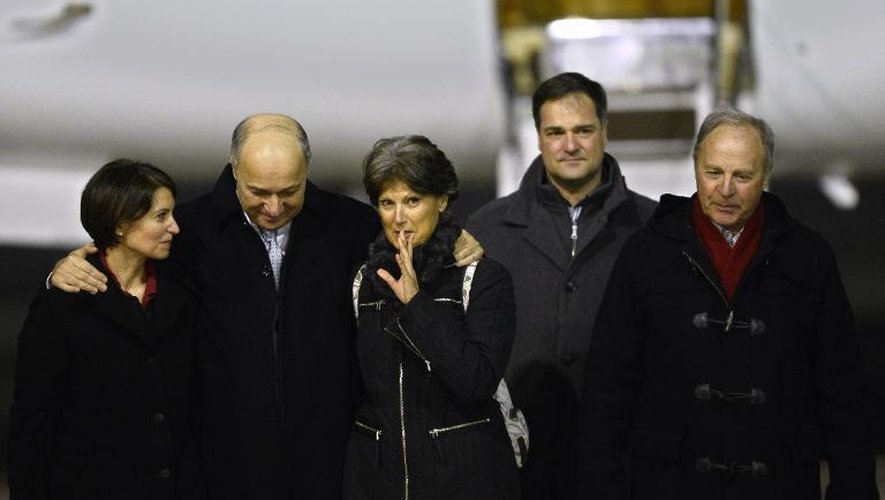 Claudia Priest (au c.) retrouvent ses proches en compagnie de Laurent Fabius (2e à g.) le 25 janvier 2015 à l'aéroport de Villacoublay