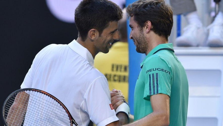 Novak Djokovic (g) serre la main de Gilles Simon, éliminé en 5 sets par le Serbe en 8e de finale de l'Open d'Australie, le 24 janvier 2016 à Melbourne
