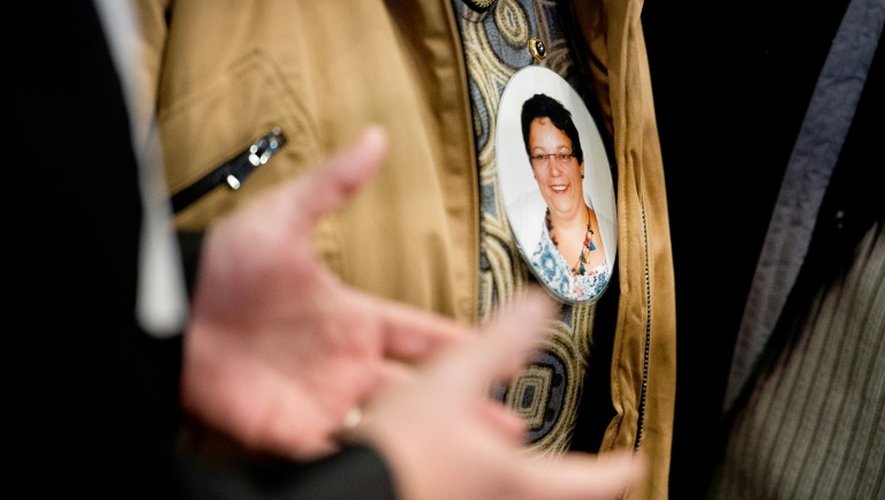 Un membre de la famille d'Anne Barbot porte le portrait de la victime en médaillon, le 14 janvier 2016 au palais de justice de Nantes