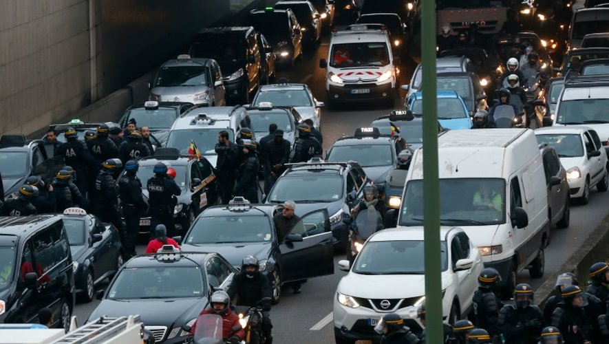 Policiers face aux taxis grévistes sur le périphérique porte Maillot à Paris