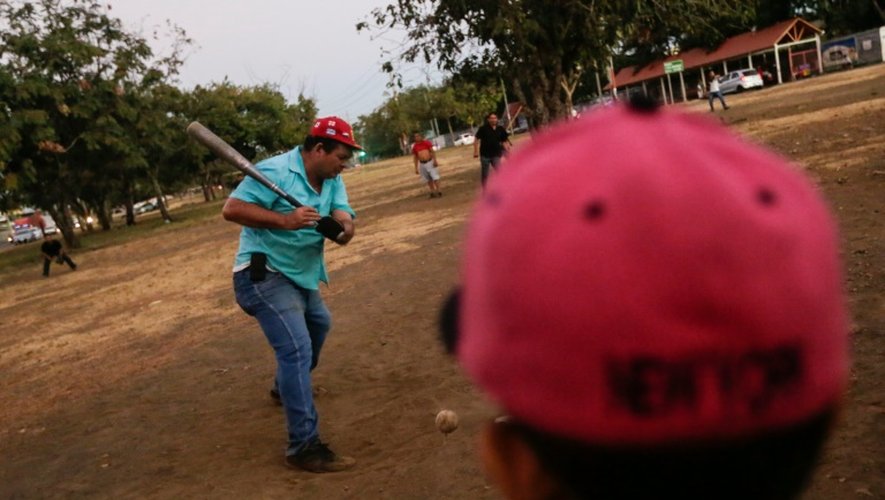 Des hommes jouent au baseball dénommé le "sport roi", dans les faubourgs de Managua, le 13 janvier 2016