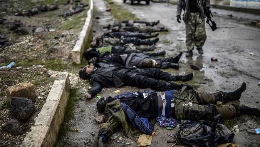 Musa, "sniper" kurde, regarde le 30 janvier 2015 les corps de membres présumés du groupe de l'Etat islamique, morts lors de la reconquête de la ville de syrienne de Kobané