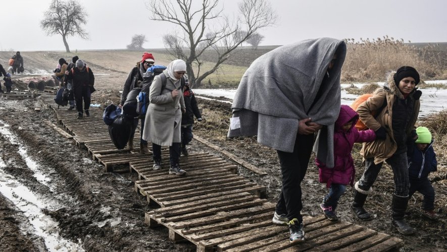 Des migrants traversent un champ boueux après avoir passé la frontière serbo-macédonienne près du village serbe de Miratovac, le 27 janvier 2016