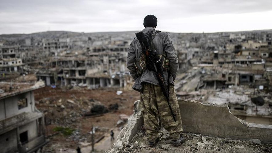 Un sniper kurde regarde la ville syrienne de Kobané en ruines, le 30 janvier 2015
