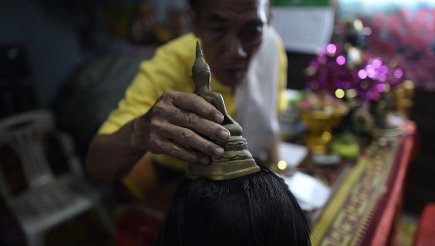 Un moine bouddhiste pratique un rituel sur une fidèle le 15 janvier 2015 dans un temple à Bangkok