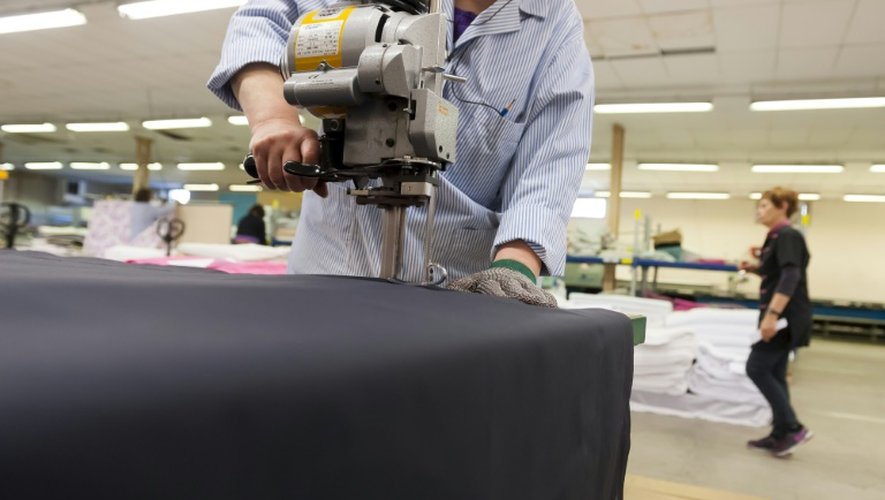 Une couturière est en train de couper un morceau de tissu à l'usine "Blanc des Vosges" à Gérardmer, le 25 janvier 2016