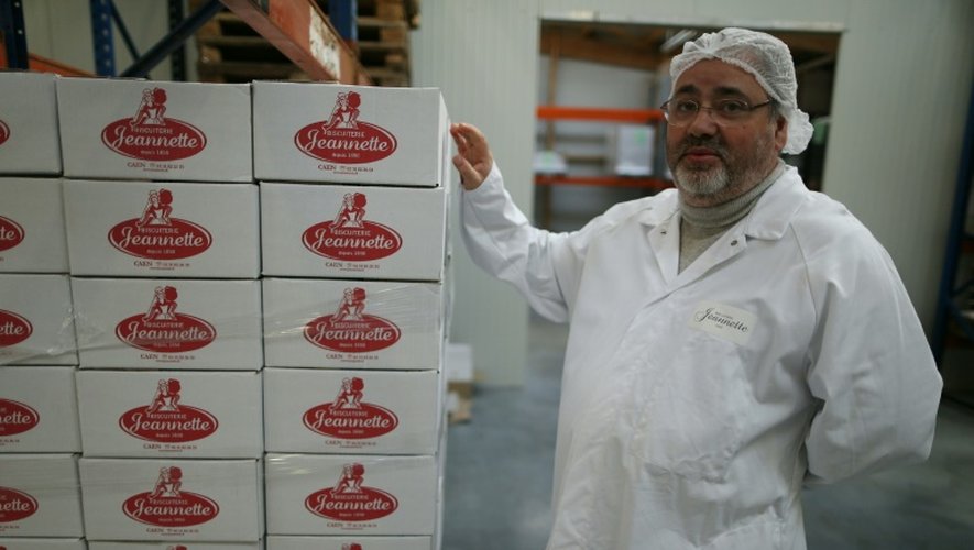 Georges Viana, propriétaire de la biscuiterie, montre dans l'usine de Démouville, le 26 janvier 2016 les cartons de madeleines Jeannette prêts à être expédiés