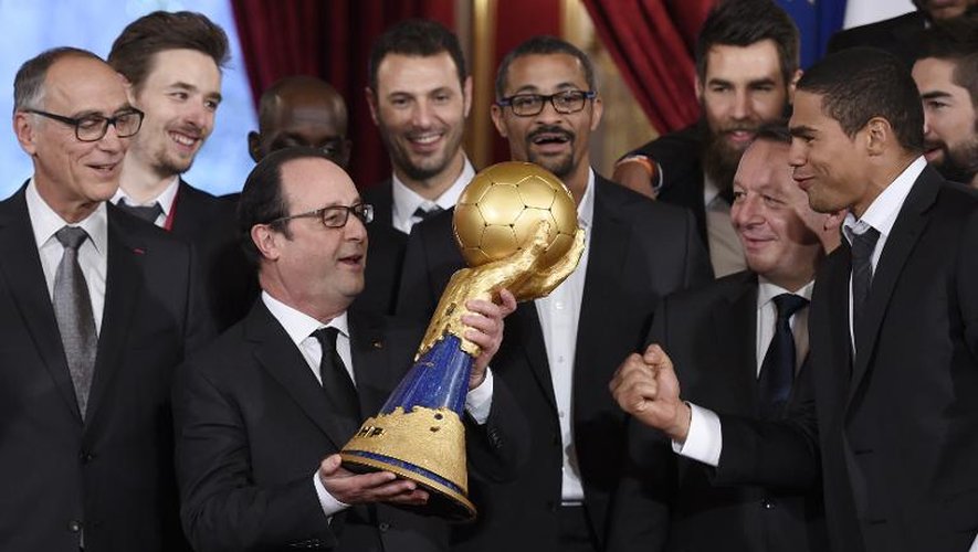 François Hollande tient la coupe du monde de handball lors de la réception des joueurs de l'équipe de France à l'Elysée, le 3 février 2015