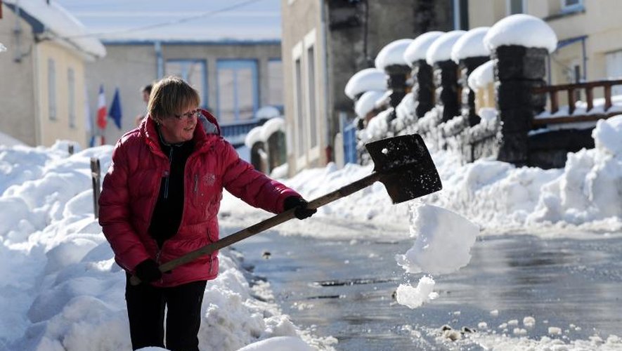 Une femme dégage la neige dans une rue de Laruns, dans une rue de Laruns, le 3 février 2015 dans les Pyrénées-Atlantique